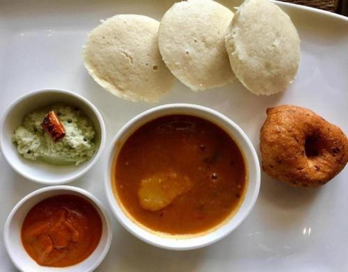 孟买Hotel Zillion Executive - Kurla West Mumbai的盘子上放着一碗食物和酱汁的白盘