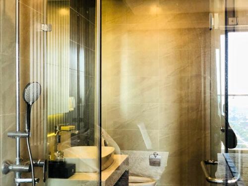 海阳Apec Mandala hotel & suites Hải dương的一间带水槽和玻璃淋浴的浴室