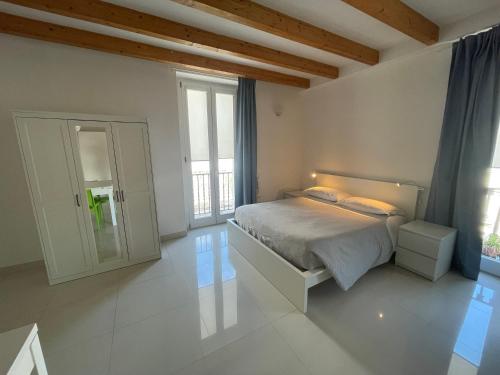 圣塞韦罗Palazzo di Fazio Suites的白色的卧室设有床和窗户