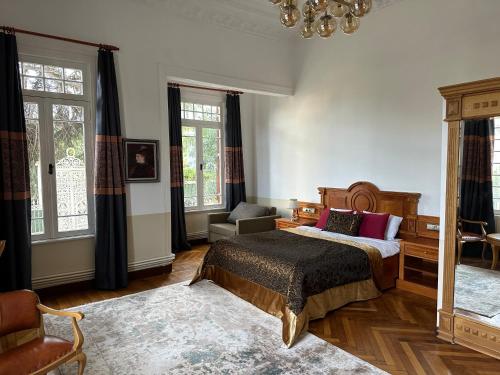 王子岛群Kensington Prince's Island Historical Mansion的一间卧室配有一张床、一把椅子和窗户。