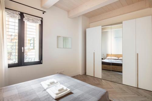 伊莫拉Piazza Savonarola 13的白色卧室配有床和镜子
