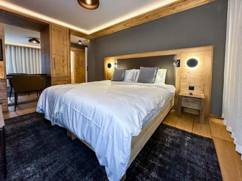 萨梅丹Chic Alpine Elegance: Designer Retreat in Samedan的一间大卧室,配有一张大床和一张桌子