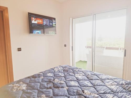 艾西拉Marina golf studio的卧室配有一张床铺,墙上配有电视