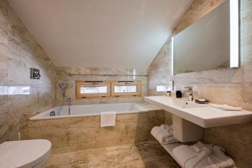 威拉尔-苏-罗伦Hotel du Lac的带浴缸、盥洗盆和卫生间的浴室