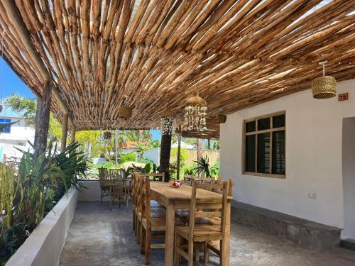 帕杰Villa Upendo Paje的庭院设有木制凉亭,配有桌椅