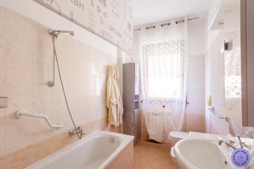阿罗纳Ca di PA' Apartment的带浴缸、卫生间和盥洗盆的浴室