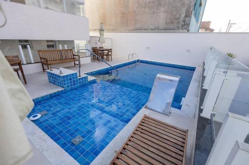 伊塔尼亚恩Apto. a 40m da praia - Itanhaém.的大楼内一个蓝色瓷砖的大型游泳池