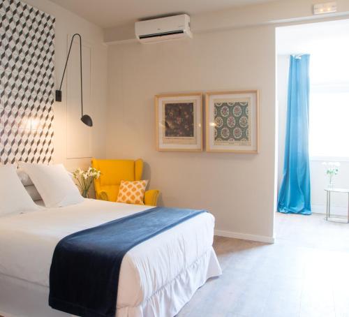 巴塞罗那圆锥形豪华住宿加早餐旅馆的一间卧室配有一张床和一张黄色椅子