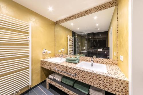 吕塞尔斯海姆PMC商务公寓的一间带两个盥洗盆和大镜子的浴室