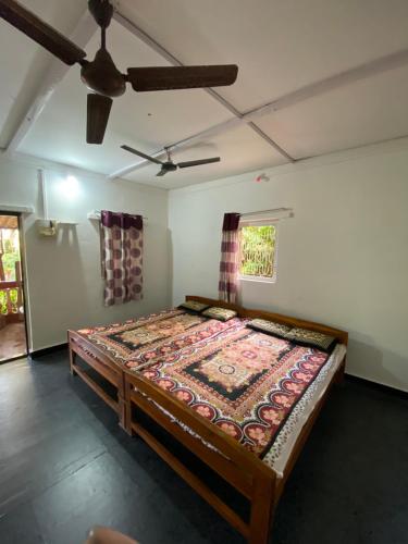 达博利Aviraj Nivas的配有吊扇的客房内的一张床位