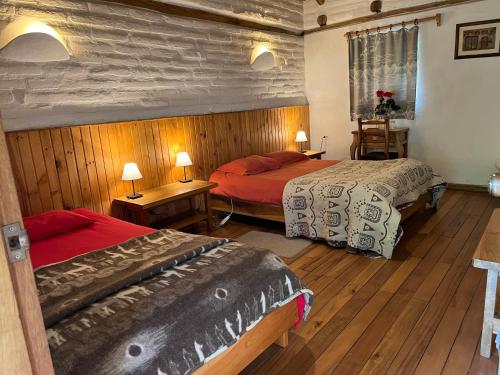 LassoHostería Hotel Cuello de Luna - Cotopaxi - Country Inn的铺有木地板的客房内的两张床