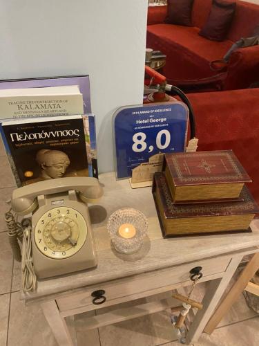 卡拉马塔乔治酒店 的一张桌子,上面有时钟和书籍