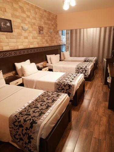 亚喀巴alnaher alkhaled boutiqu的一间酒店客房,房间内设有三张床