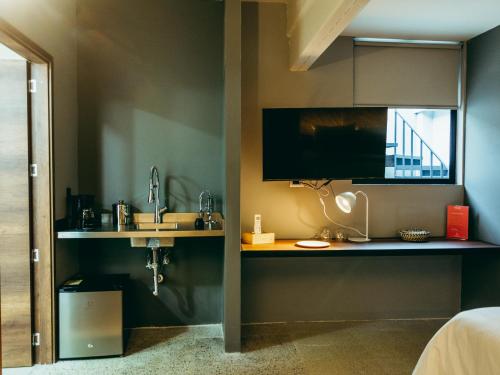 麦德林I Believe- All Suite Manila-Poblado的卧室设有水槽和墙上的电视