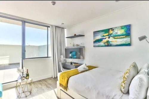 开普敦Modern Luxe Getaway for 2 with Stunning Cape Town Views, Fast WiFi, Queen Bed, Voice Control, Chic & Stylish Comfort的白色的卧室设有床和大窗户