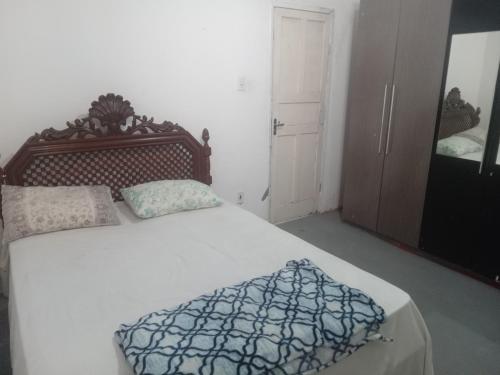 维多利亚Hostel Leonardo Quarto A的一间卧室配有一张大床和木制床头板