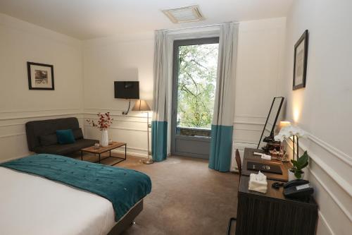 布里夫拉盖亚尔德Hôtel Château de Lacan的酒店客房设有床和窗户。