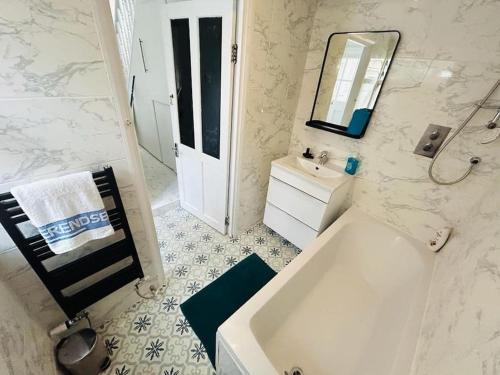 伦敦Elegant House in Stratford的带浴缸、水槽和镜子的浴室