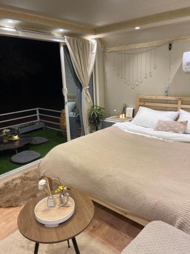 欧拉Five caravan的一间卧室配有一张大床和一张桌子