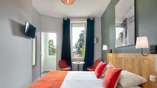 南特Hôtel Coeur De Loire的一间卧室配有一张带红色枕头的床和一扇窗户