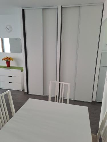 维齐尔STUDIO CENTRE HISTORIQUE的一间配备有白色桌子和两把椅子的用餐室