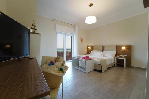 克罗托内hotel villaggio Casarossa的一间卧室设有一张床和一间客厅。