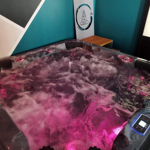 SaulzoirAJC Ô Spa的客房内的浴缸里装满了粉红色的水