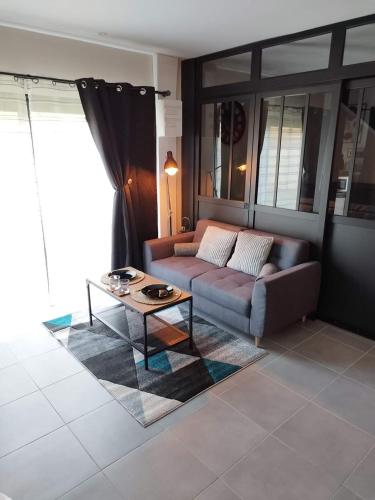 SaulzoirAJC Ô Spa的带沙发和咖啡桌的客厅