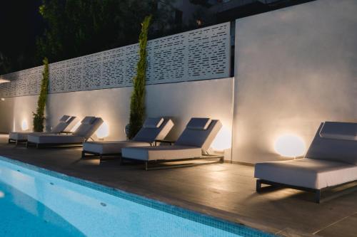 雅典巴西套房精品酒店 的一组躺椅,位于游泳池旁
