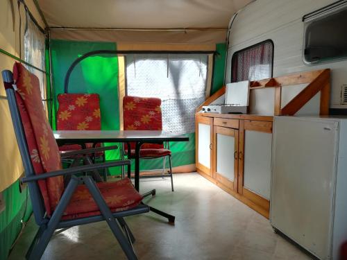 乌格连Room in Cabin - Caravan near the sea 1的厨房配有带桌椅的拖车