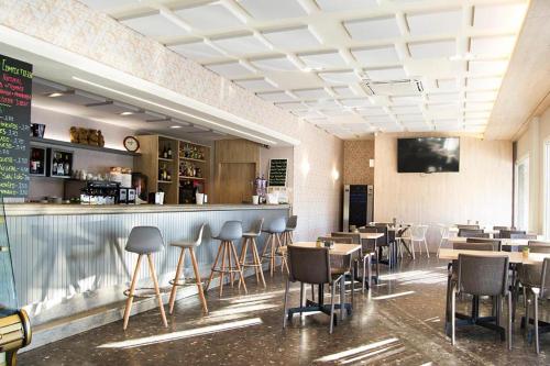 维拉波圣路易酒店的餐厅设有酒吧,配有桌椅