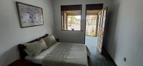 SítioPousada Marinheiro的一间卧室设有一张床和一个开放式门
