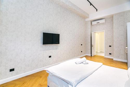 巴库Comfort City center 2 bedrooms的白色的客房设有一张床和墙上的电视