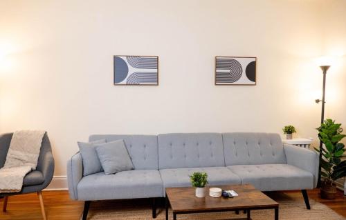 纽约Superb 1BR Apartment in NYC!的客厅配有蓝色的沙发和桌子