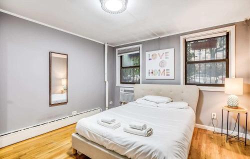 纽约Superb 1BR Apartment in NYC!的一间卧室设有一张大床和两个窗户。