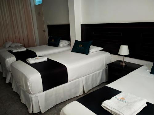 皮乌拉Di Costa Hotel的酒店客房的三张床,配有毛巾