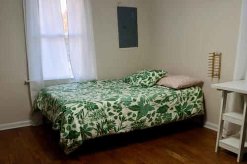  东港Cozy East Haven Apartment - Walk to Beach!的一间卧室配有一张带绿色和白色毯子的床
