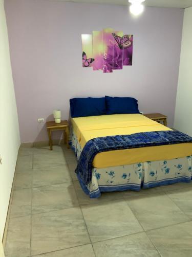 埃斯特利LA DOLCE VITA FRANCOPHONE的卧室配有一张床,墙上挂有绘画作品
