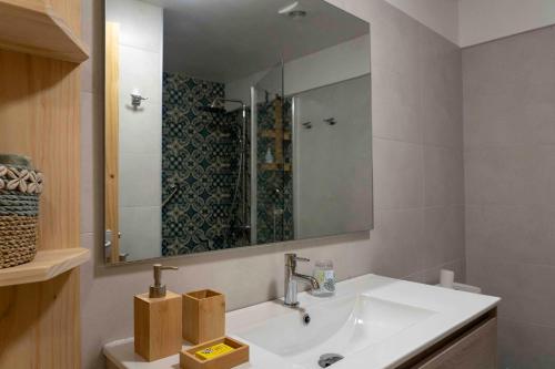 帕皮提La Maison de Paofai的浴室设有白色水槽和镜子