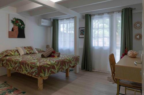 帕皮提La Maison de Paofai的卧室配有床、桌子和窗户。
