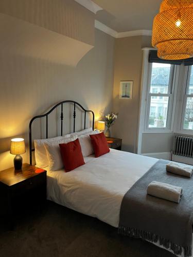 布莱顿霍夫Contemporary beach apartment的卧室配有带红色枕头的大型白色床