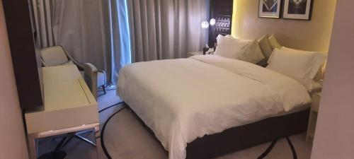 利雅德Luxury apartments - Damac tower的酒店客房配有一张床、一张书桌和一台电视。