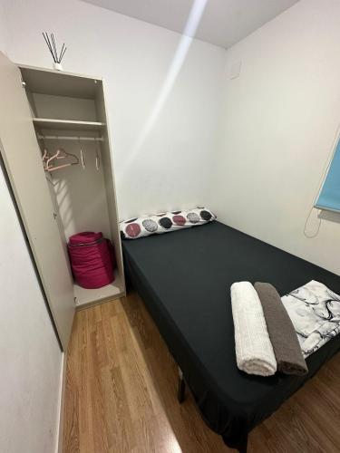 马德里Fast Single Rooms的一间卧室配有一张黑色的床和一个衣柜