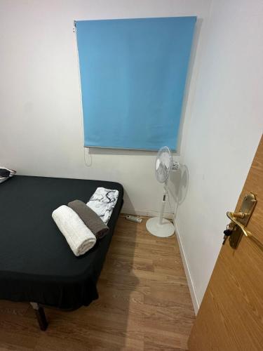 马德里Fast Single Rooms的小房间设有一张床和一个风扇