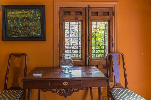 帕托内斯El Mirador de Las Jaras的一张桌子和两把椅子,上面装有葡萄酒杯