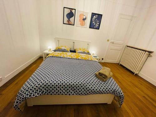 新城勒鲁瓦Grande maison : Près de Paris/Orly的一间卧室配有一张带黑色和黄色棉被的床