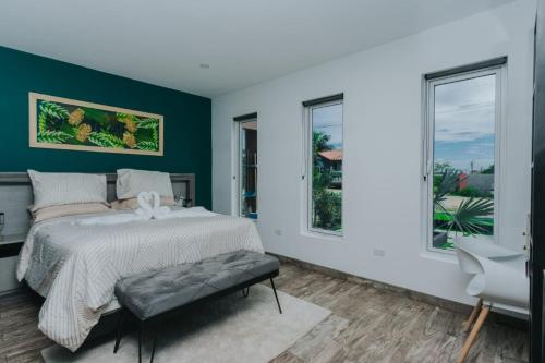 奥拉涅斯塔德Hidden Villa Aruba的一间卧室设有一张床和两个窗户。