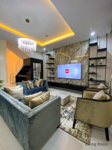 IbejuIVYs 4 Bedroom Luxury Entire Apartment Duplex with Wifi in Lekki的带沙发和平面电视的客厅