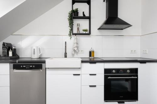 施韦特Lichterfüllte Erholungsoase für Groß und Klein的白色的厨房配有黑白电器