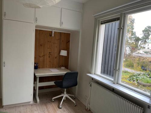 胡丁厄Nice two room flat 15 minutes from Stockholm C .的窗户旁的办公室,配有桌子和椅子